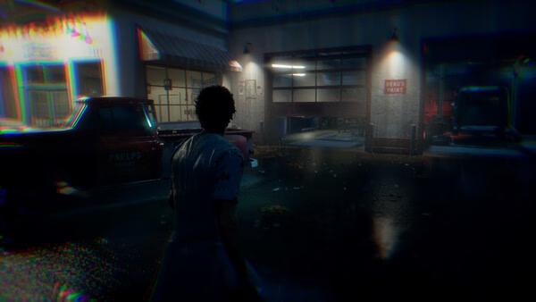 Screenshot from "Halloween: The Game" showing a character in a dark, rainy street near a garage with dim lighting.