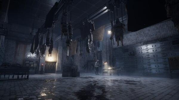 Screenshot from Lies of P: Overture showing a dimly lit, eerie factory with hanging figures and a character standing in the distance.