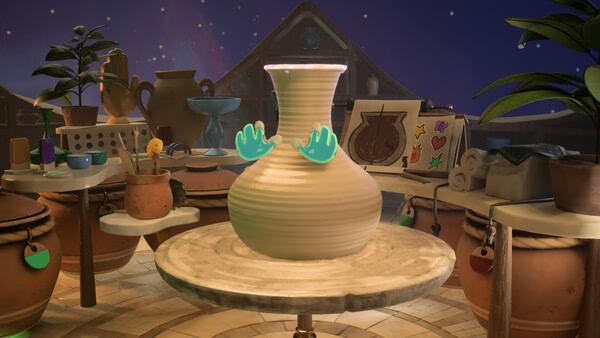 Screenshot from Kiln showing a pottery studio with a spinning vase on a wheel, surrounded by tools and decorations.