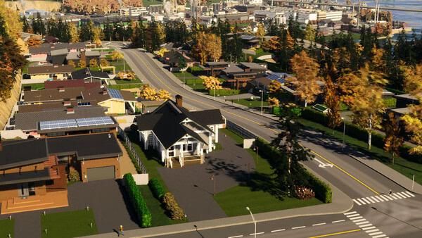 A Cities: Skylines II screenshot showing a suburban neighborhood with modern houses, autumn trees, and winding roads.