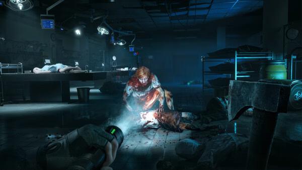 A "No More Room in Hell 2" screenshot showing a zombie in a dark morgue with a flashlight illuminating the scene.