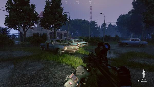Screenshot from the game Active Matter showing a first-person view of a weapon aimed at abandoned cars in a grassy area at dusk.
