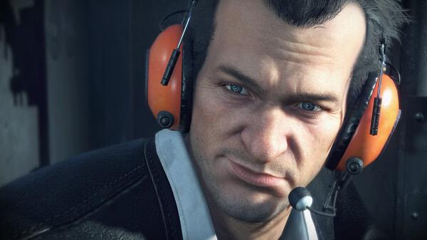 Screenshot from Dead Rising Deluxe Remaster showing a close-up of a man wearing orange headphones and a microphone.