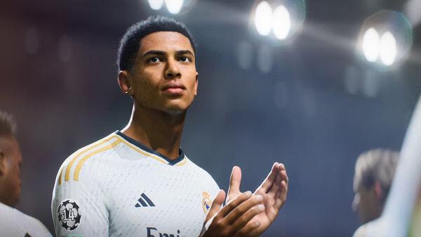 A screenshot from EA SPORTS FC 24 showing a football player in a white jersey clapping under stadium lights.