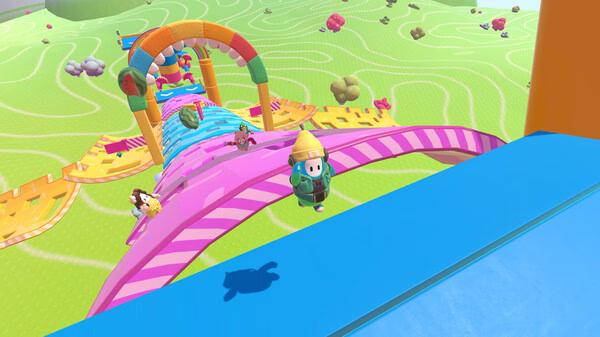 Screenshot of Fall Guys showing colorful characters racing on a vibrant obstacle course with slides and arches.