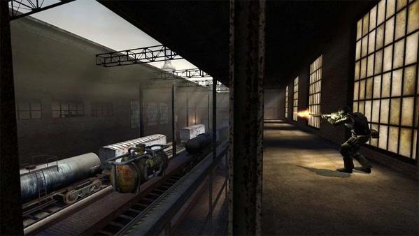 A Counter-Strike: Source screenshot showing a player firing a weapon in a warehouse near train cars and industrial equipment.