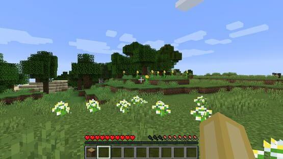 A screenshot of Minecraft: Java Edition showing a grassy field with trees, flowers, and the player's inventory bar.