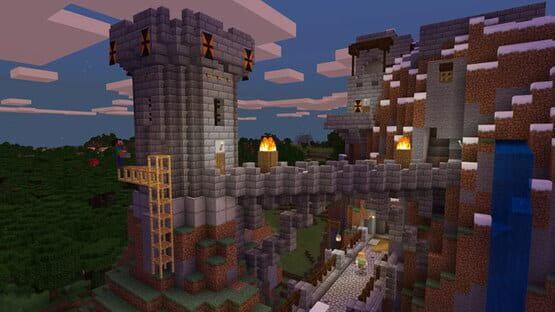 A screenshot from Minecraft: Java Edition showing a medieval-style stone castle with towers, torches, and a wooden bridge at sunset.