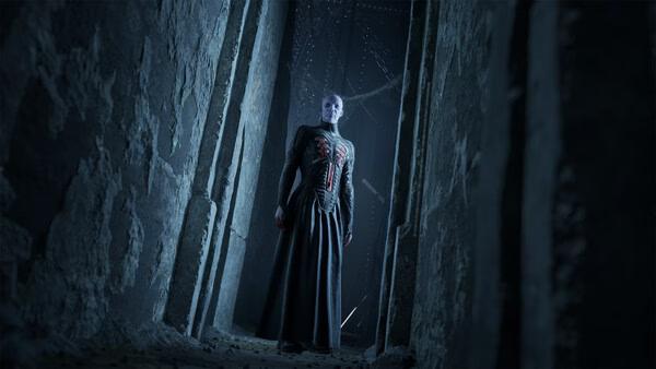 Clive Barker's Hellraiser: Revival screenshot showing a pale Cenobite in a dark stone corridor.