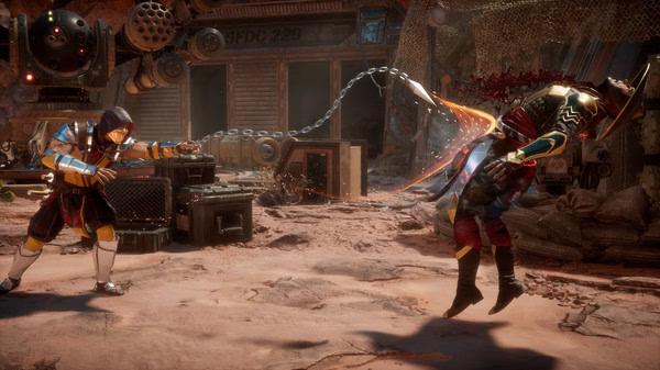 Screenshot from Mortal Kombat 11 showing a character using a chain weapon to attack an opponent in a desert setting.