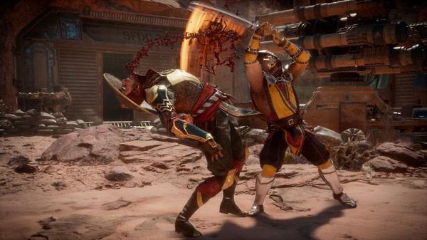 Mortal Kombat 11 screenshot: A character in yellow armor attacks an opponent with a fiery strike in a desert arena.