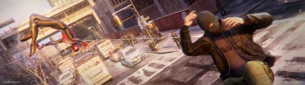 Screenshot from Marvel's Spider-Man: Miles Morales showing Miles web-swinging while disarming an enemy on a snowy city street.