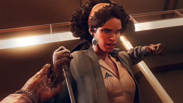 A tense moment in Deathloop screenshot: a character holds a knife to a woman with curly hair and a headband inside a modern building.