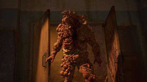 A bloater stands menacingly in an open doorway in a dark room. The Last of Us Part I screenshot.