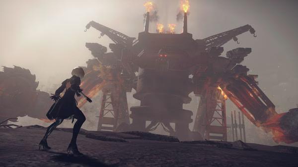 NieR:Automata™ screenshot showing 2B facing a towering, fiery mechanical boss in a desolate, smoky battlefield.