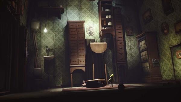 Screenshot from Little Nightmares showing a dimly lit room with a small figure in a yellow raincoat surrounded by tall furniture.