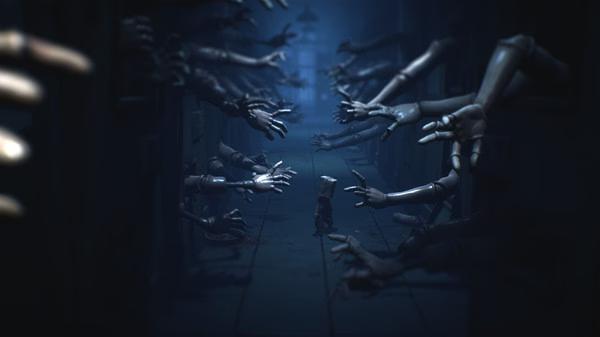 Little Nightmares II screenshot: A small figure navigates a dark hallway, surrounded by numerous reaching mannequin hands.