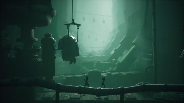 Screenshot from Little Nightmares III showing two silhouetted figures walking on a pipe in a dim, eerie industrial setting.