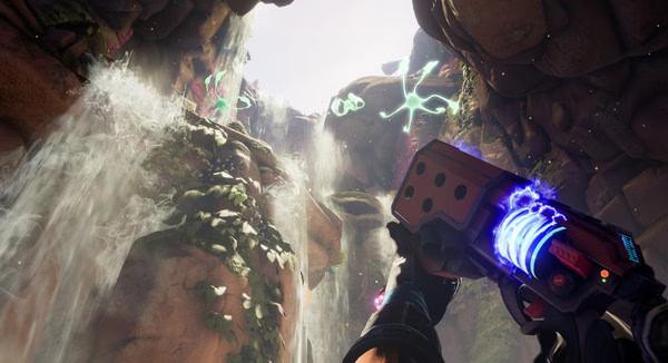 Screenshot from Journey To The Savage Planet showing a player aiming a glowing weapon at vibrant alien plants and cascading waterfalls.