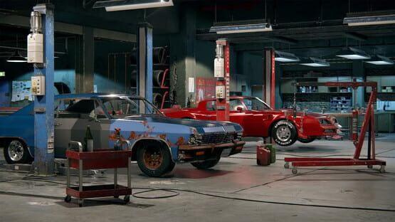 Car Mechanic Simulator 2018 screenshot: A garage with two cars, one rusty and blue, the other red, surrounded by tools and equipment.