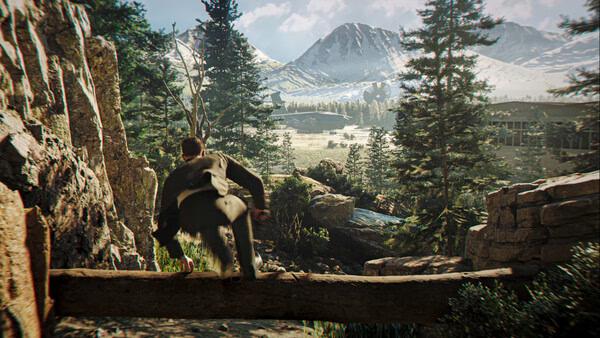 Screenshot from 007 First Light: A character crosses a log bridge in a scenic forest with mountains in the background.