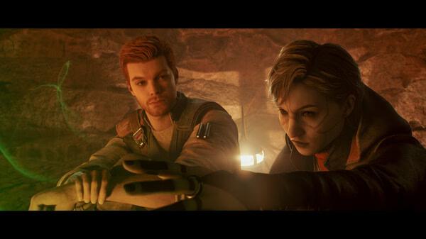 Screenshot from STAR WARS Jedi: Survivor™ showing two characters in a dimly lit cave, holding a glowing green object.