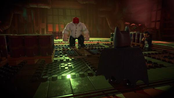 LEGO® Batman™: Legacy of the Dark Knight screenshot featuring Batman facing off against a large, muscular figure in a dimly lit room.