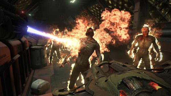 DOOM Eternal screenshot: A fiery demon is hit by a laser beam while other burning demons approach in a dark, metallic corridor.