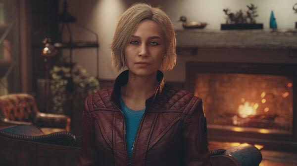 A Starfield screenshot showing a character with blond hair in a red jacket, standing in a cozy room with a lit fireplace.