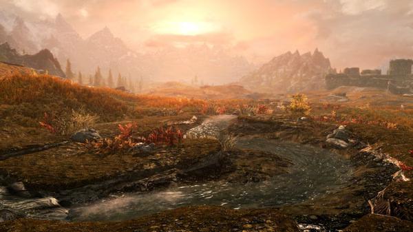 A screenshot from The Elder Scrolls V: Skyrim Special Edition showing a scenic landscape with a stream and mountains at sunset.