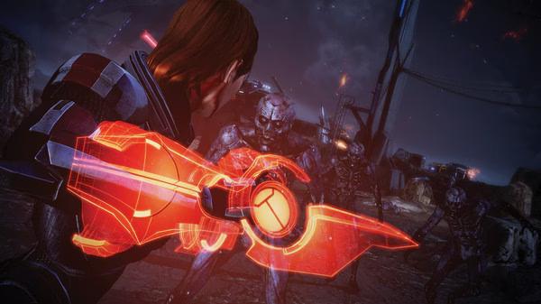 Screenshot from Mass Effect™ Legendary Edition showing a character wielding a glowing orange weapon against alien foes.