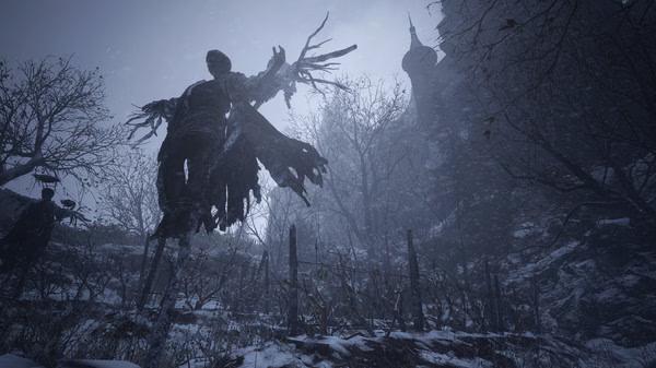 A screenshot of Resident Evil Village showing a snowy landscape with a tall, eerie scarecrow and a castle in the background.