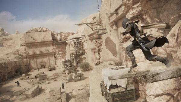 Screenshot from Assassin's Creed Mirage showing a hooded character leaping across ancient ruins in a desert landscape.