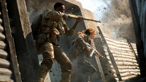 Battlefield™ 2042 screenshot: Two soldiers in combat gear emerge from cover amid smoke and debris during intense battle action.