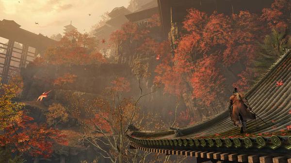 Screenshot from Sekiro™: Shadows Die Twice - GOTY Edition showing a character on a roof surrounded by vibrant autumn trees and mountains.