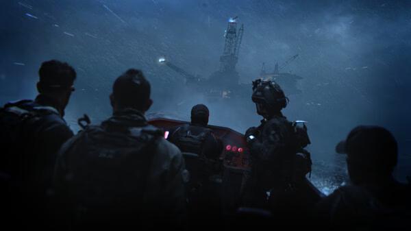 Game screenshot from Call of Duty®: Modern Warfare® II showing soldiers approaching an oil rig at night in stormy weather.