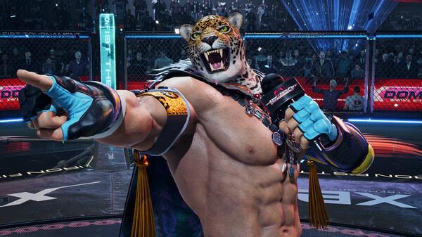 King, a character in TEKKEN 8, holds a microphone and points forward in an arena. TEKKEN 8 game screenshot.