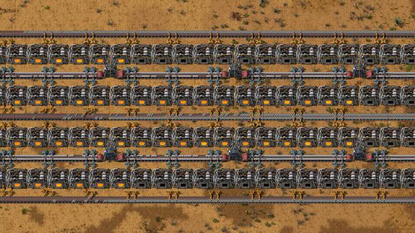 Factorio screenshot showing a large assembly line with conveyor belts, machines, and robotic arms on a desert-themed terrain.