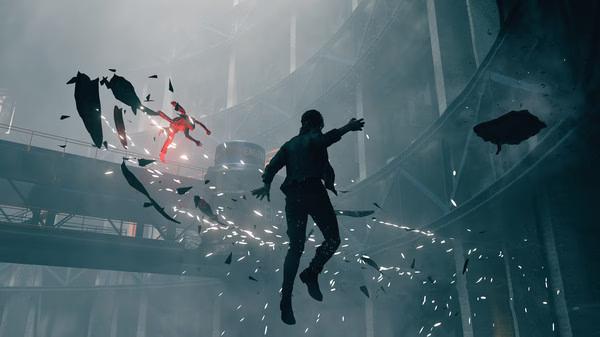Screenshot from CONTROL Ultimate Edition showing a character levitating amidst flying debris in an industrial setting.