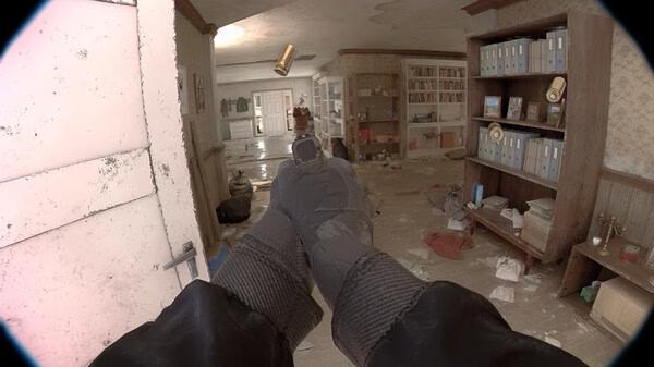 Screenshot from 'Unrecord' showing a first-person perspective of hands holding a gun in a cluttered, dimly-lit room with shelves and scattered items.