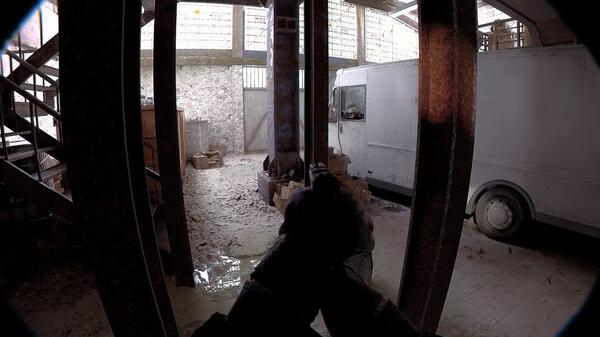 Screenshot from Unrecord showing a first-person view inside a warehouse with a gun aimed at a white van.