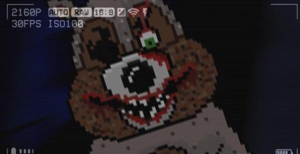 Game screenshot from The Last Night showing a pixelated, menacing bear face with one green eye and sharp teeth, resembling a video camera feed.