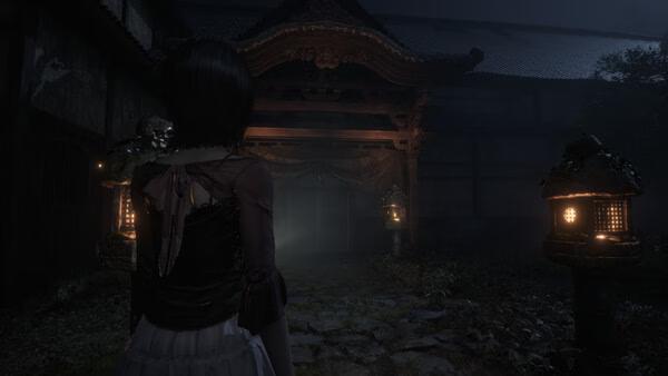 Screenshot from FATAL FRAME II: Crimson Butterfly REMAKE showing a character approaching a dimly lit, eerie shrine at night.