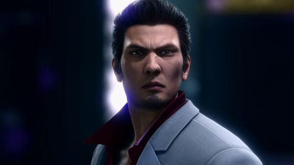 A Yakuza Kiwami 2 screenshot featuring a man in a gray suit with a red shirt collar, set against a dark, glowing backdrop.
