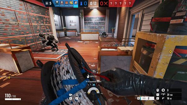 Screenshot from Tom Clancy's Rainbow Six Siege showing a player deploying barbed wire inside a room, with teammates preparing defenses.