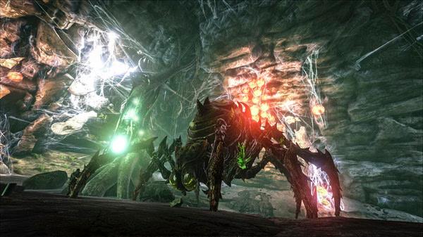 ARK: Survival Evolved screenshot showing a giant spider-like creature with glowing green and red accents in a dark cave.