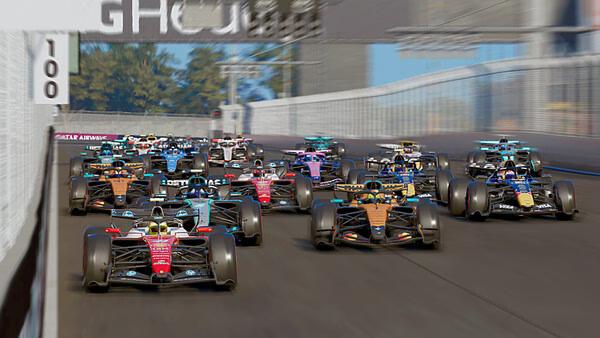 F1 25 screenshot: A crowded starting grid with multiple Formula 1 cars racing down a straight track surrounded by barriers.