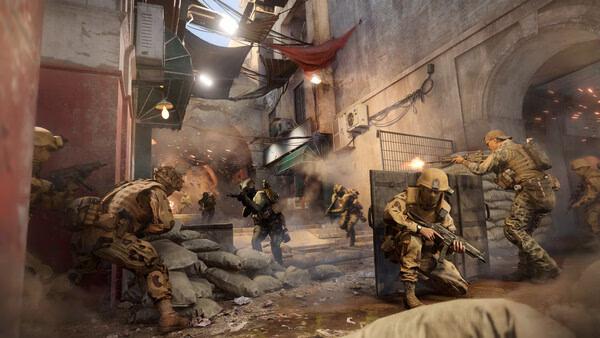Battlefield 6 screenshot: Soldiers engage in intense urban combat, using barriers for cover amidst flying debris and gunfire.