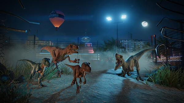 Screenshot from Jurassic World Evolution 3 showing a group of dinosaurs roaming under a moonlit sky near a fenced enclosure.
