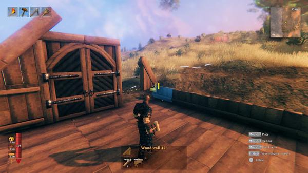 A Valheim screenshot showing a player building a wooden structure with a hammer, set in a grassy outdoor environment.